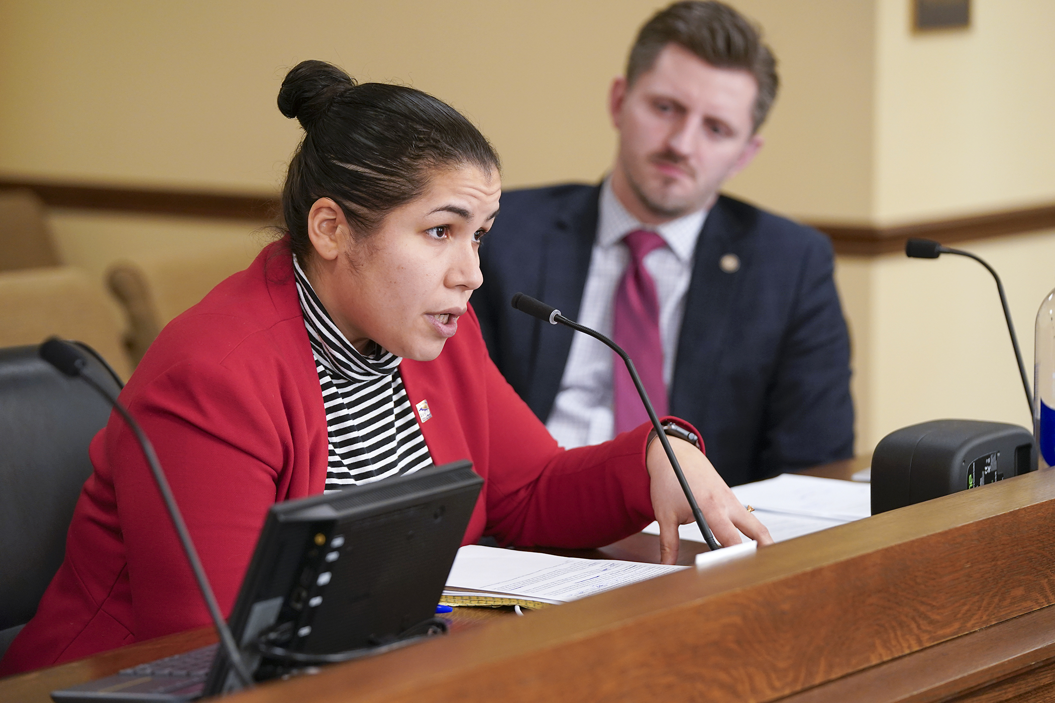 Samantha Diaz, political director of SEIU Local 26, testifies before the House Higher Education Finance and Policy Committee Jan. 11 in opposition to HF10. Looking on is Rep. Issac Schultz, the bill sponsor. (Photo by Michele Jokinen)